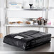 A black Intedge insulated delivery bag on a table.
