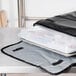 An Intedge black vinyl insulated delivery bag with a full size sheet pan inside.