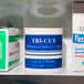 A white shelf with a container of Medique tri-cut adhesive tape.