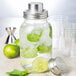 A Tablecraft glass Mason jar cocktail shaker with a lid, ice, and mint leaves.