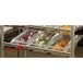 A shelf with plastic containers of vegetables in a Cambro Camshelving® rack with an Angled Divider Bar.