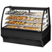 A True curved glass black dry bakery display case filled with trays of pastries.