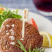 A piece of steak with a Tablecraft bamboo meat marker that says "Well Done" sticking out of it.