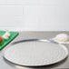 An American Metalcraft heavy weight aluminum pizza pan with nibs on a counter.