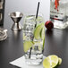 A Reserve by Libbey Symmetry cooler glass filled with water and lime slices with a straw.