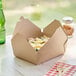 A Choice Kraft paper take-out box filled with food on a table.