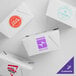 A set of customizable white microwavable folded paper take-out containers with various printed logos.