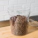 A Carlisle clear round polycarbonate food storage container full of chocolate chips.