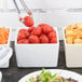 A white Tablecraft straight sided bowl filled with salad and tomatoes.