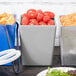 A Tablecraft gray bowl filled with tomatoes on a table in a salad bar.