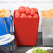 A red Tablecraft straight sided bowl full of tomatoes on a table in a salad bar.