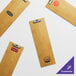 A group of natural wood color menu holders with silver metal clips.