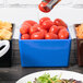 A Tablecraft blue speckled bowl with tomatoes on a salad bar table.