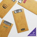 A group of Choice customizable wooden menu holders with metal clips on a table.