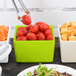 A green Tablecraft bowl filled with tomatoes.