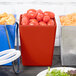 A Tablecraft copper bowl full of tomatoes on a table with other containers of food.