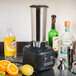 A Hamilton Beach commercial bar blender on a counter with a metal funnel of liquid inside.