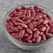 A glass bowl of dark red kidney beans.