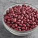 A glass bowl of dried small red beans.