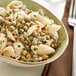 A close-up of a bowl of pasta with whole green peas.