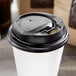 A white paper cup with a black Choice hinged lid.