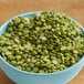 A bowl of Organic Dried Green Split Peas on a wooden table.