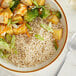 A bowl of Organic White Long Grain Rice with broccoli and chicken next to a fork.