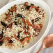 A bowl of Regal long grain rice with dried mushrooms and a spoon.