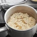 A pot of Regal brown long grain rice with water on a stove.