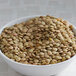 A bowl of Regal dried green lentils on a table.