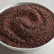 A bowl of black organic quinoa seeds on a table.