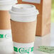 A white EcoChoice coffee cup with a brown Kraft sleeve on a counter.