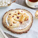 A plate of pastries and tea with an 8" silver foil lace doily on the table.