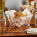 A Clipper Mill stainless steel oval basket filled with fried chicken on a table.