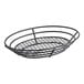 A Clipper Mill black metal oval basket with raised grid base and wire handles.