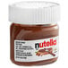 A Nutella hazelnut spread mini glass jar on a piece of bread.