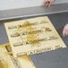 A person's hand placing a yellow Rubbermaid absorbent pad on a wet floor.