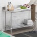 A Regency stainless steel work table with undershelf in a kitchen.