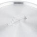 A Vollrath stainless steel lid with a handle on a white surface.