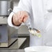 A chef using a Vollrath hooked handle slotted spoon to serve vegetables.