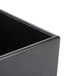 A black Cal-Mil cube riser on a table.