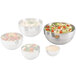 A white Vollrath stainless steel bowl filled with salad with tomatoes and lettuce.