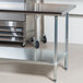 An Advance Tabco stainless steel work table with a galvanized undershelf.