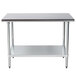 An Advance Tabco stainless steel work table with a galvanized undershelf.