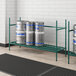 A Regency green epoxy shelving frame holding beer kegs.