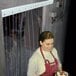 a woman wearing an apron and holding a cake