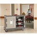 A Cambro granite green meal delivery cart with trays on it.