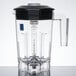 A clear plastic Waring blender jar with a black lid.