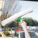 A hand using Unger ThePad StripWasher to clean a window.