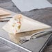 A silver tray with two Tablecraft wooden serving cones filled with food.